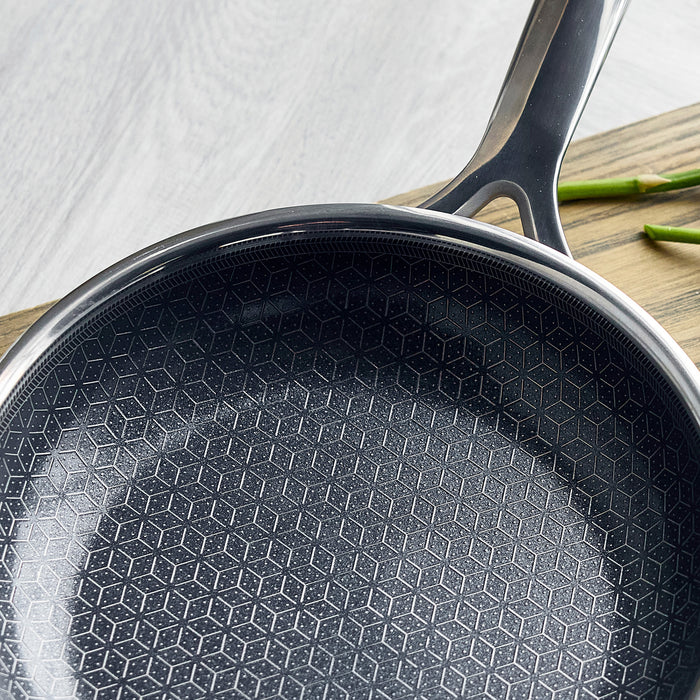Two gray hybrid ceramic nonstick frypans, 10 and 12, on a wooden surface with asparagus beside them.
