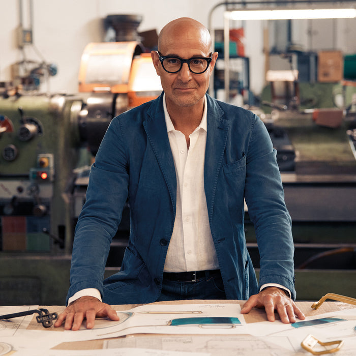 Man in glasses and blue blazer reviews Venetian teal 4-quart saucepan plans at a workbench.