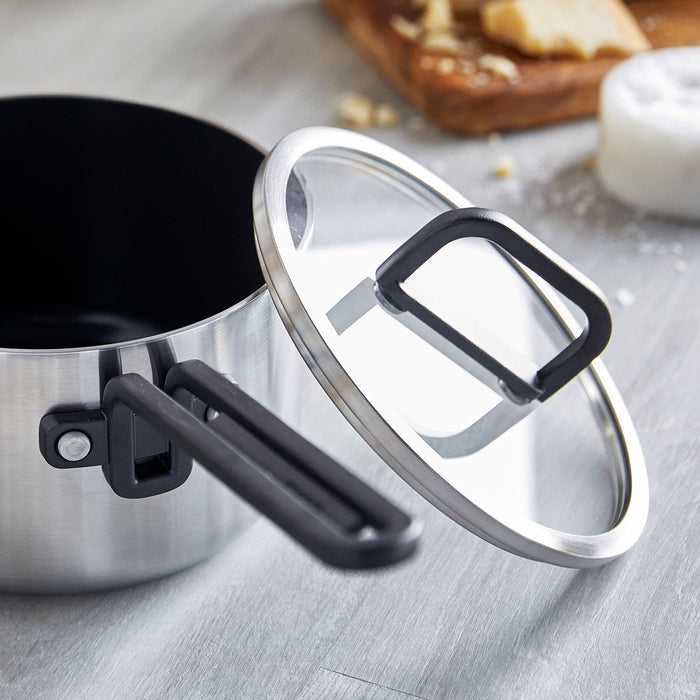 Stainless steel 2-quart saucepan with ceramic nonstick coating and lid on a gray countertop.