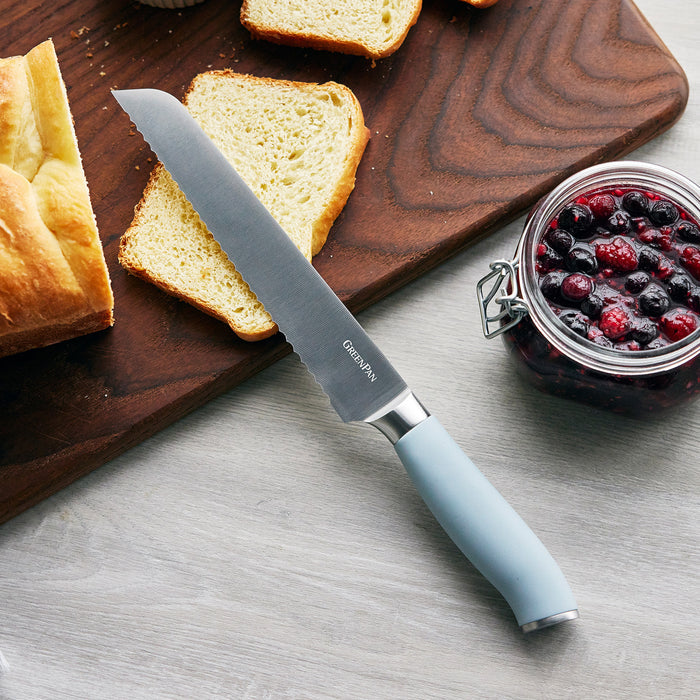 Sixteen-piece blue haze titanium knife block set on a board, with bread and mixed berries beside it.