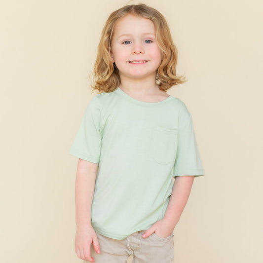 Young child wearing the Toddler Crew Neck Tee in Basil paired with a khaki colored short