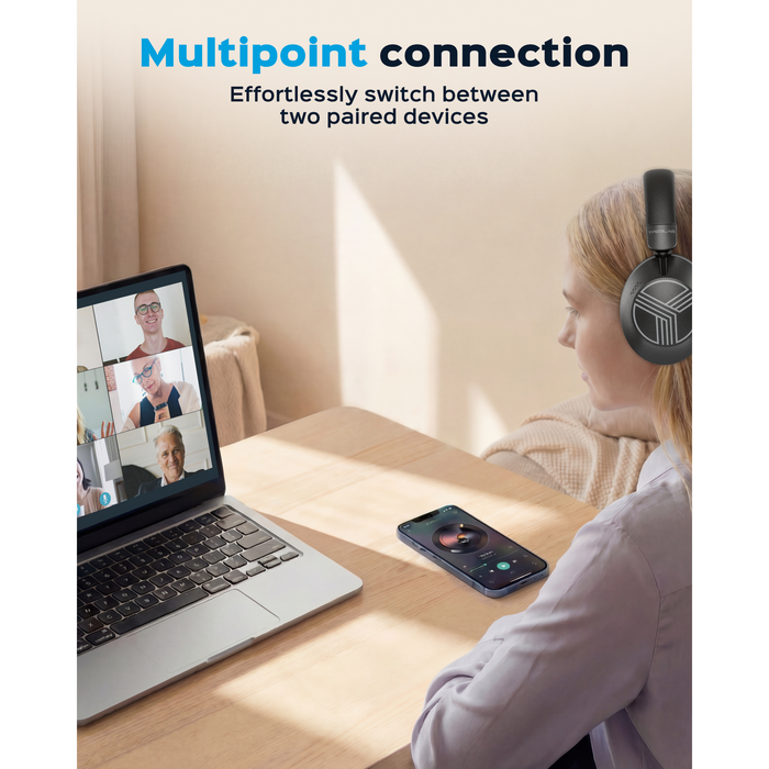 Person using headphones with a laptop and phone, emphasizing multipoint connection.