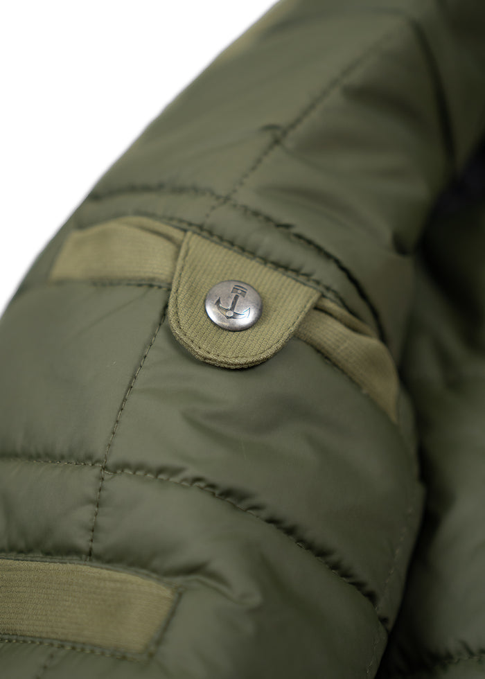 Close-up of a green quilted jacket sleeve with a metal anchor button and stitched details, highlighting its rugged design.