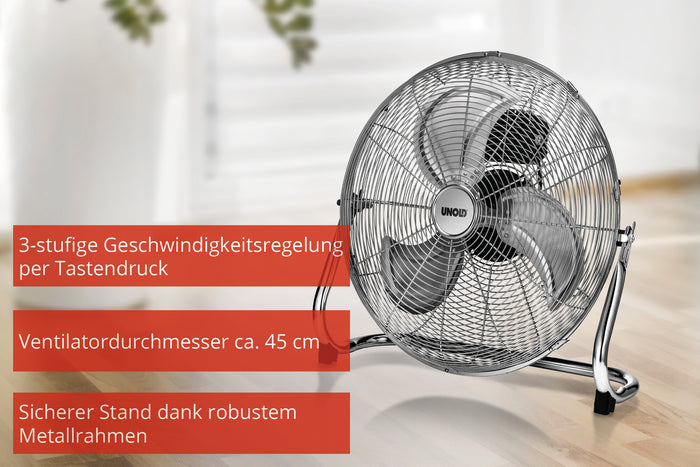 Die Unold WINDMASCHINE SPEED, ein silberner Standventilator mit drei Flügeln und stabilem Metallrahmen, steht auf einem Holzboden. Rote Textfelder in deutscher Sprache heben die einstellbare Geschwindigkeit und einen Ventilatordurchmesser von 45 cm hervor.