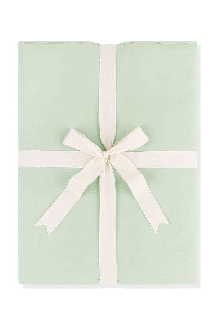 Youth Blanket in Basil 1.0 shown wrapped in its packaging tied with a linen bow