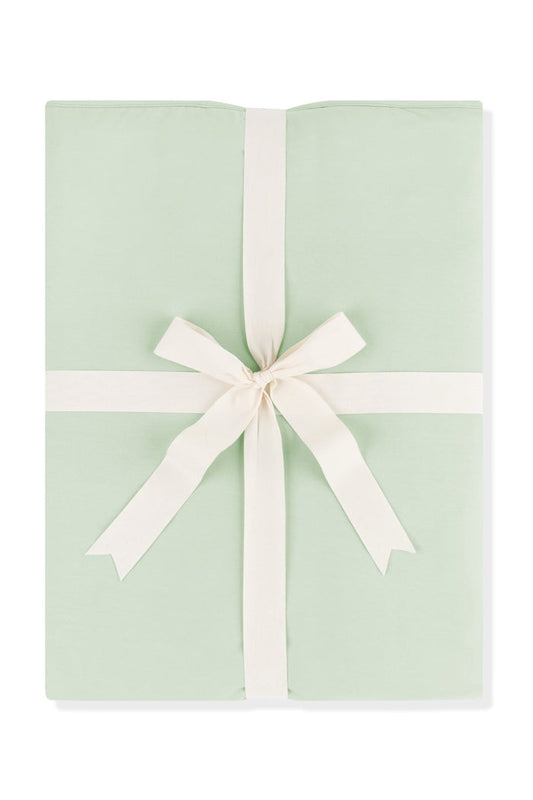 Youth Blanket in Basil 1.0 shown wrapped in its packaging tied with a linen bow