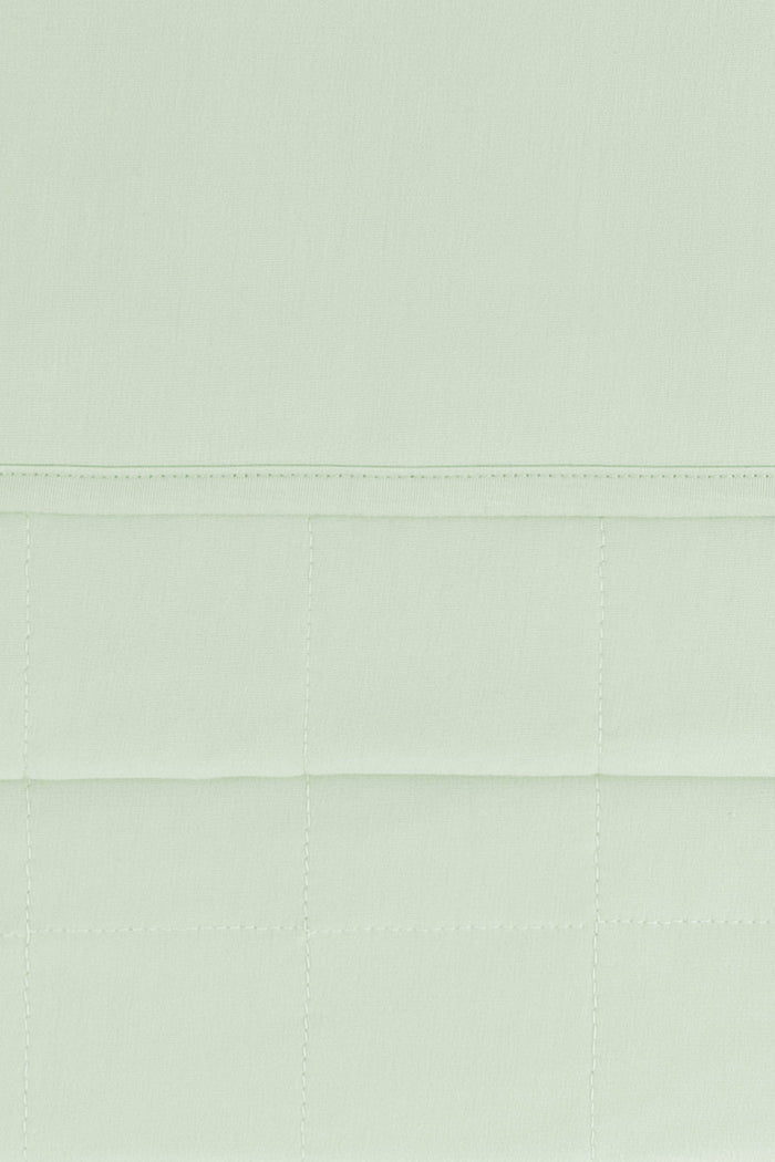 Close up of the Youth Blanket in Basil 1.0 showing the quilted backing and smooth top layer