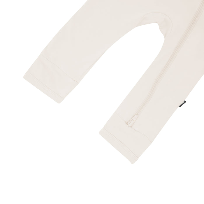 Close up of open feet on Kyte Baby Zippered Romper in Oat