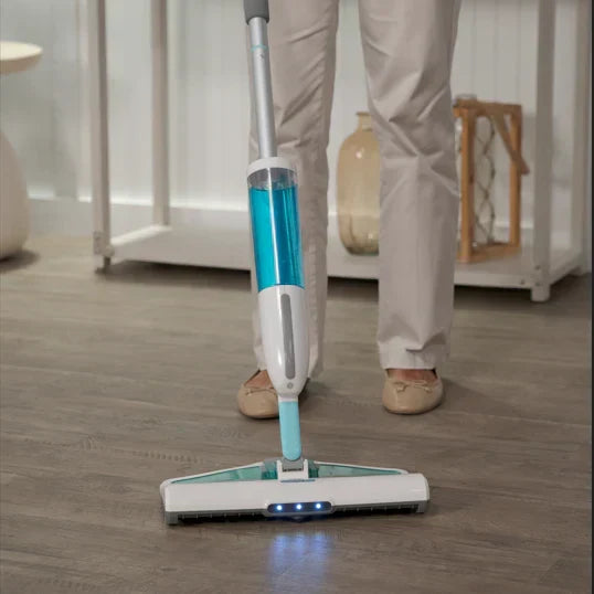 Person using a handheld vacuum cleaner on a wooden floor